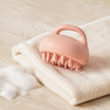 Brosse de massage du cuir chevelu LYN Beauty dans une ambiance spa avec serviette